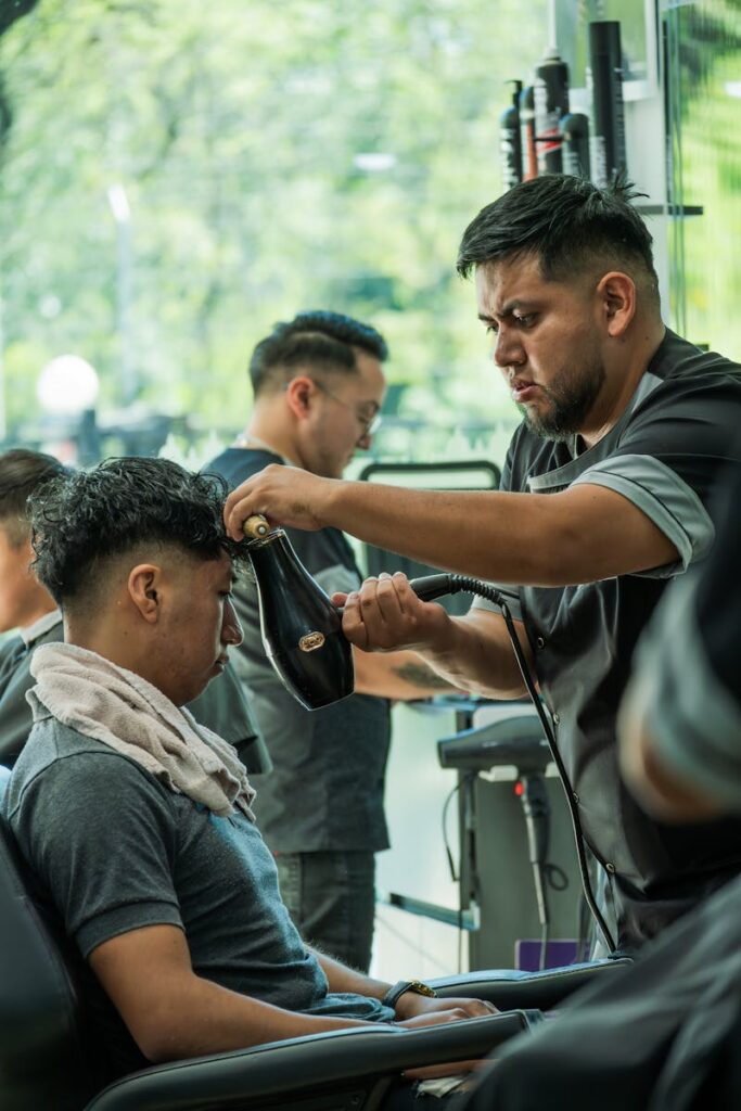 Sobre Centro Belleza Dara - Barber meticulously styles a client's hair in a modern Cuenca salon.