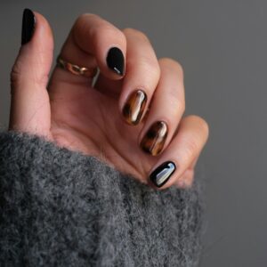 person wearing silver ring with black manicure
